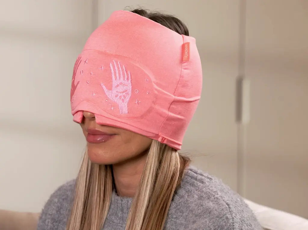 Resting in an armchair wearing the Soothefy cooling cap with the eye mask down
